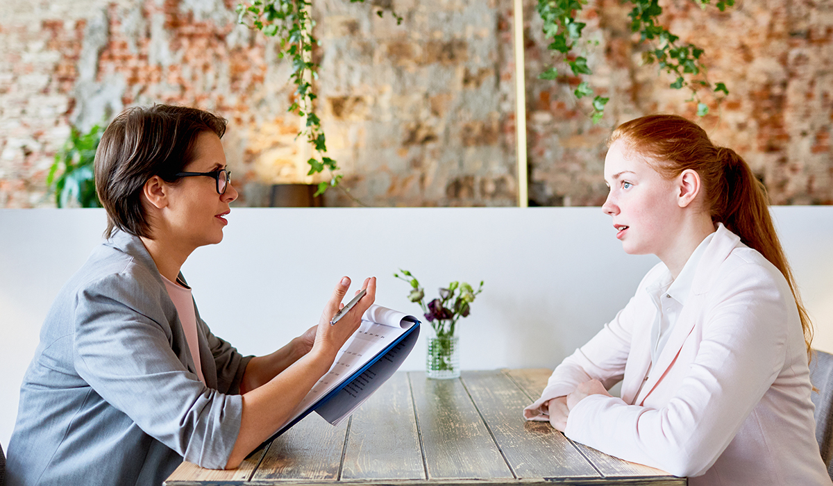 Owner of a restaurant interviewing a young girl for a job. Image credit: Adobe Stock